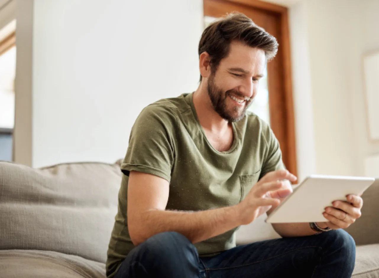 Man in sofa kijkt op tablet